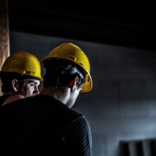 two construction workers wearing yellow hard hats